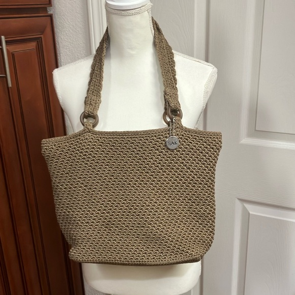 Sac Bandoulière The Sak En Crochet Beige Avec Fond Métallisé Doré Et Breloque